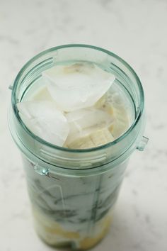 a glass jar filled with ice and banana slices