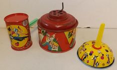 three tin canisters and a toothbrush on a white counter top with a yellow lid