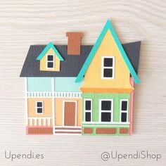 a paper cutout of a house on top of a wooden table with the words upendies