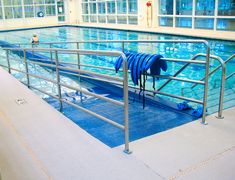 an empty swimming pool with metal railings and blue towels hanging from the side of it