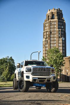 a white truck parked in front of a tall building