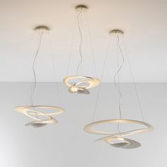 three circular lights suspended from the ceiling in an empty room