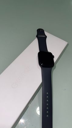 an apple watch sitting on top of a white box