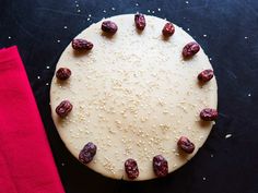 a cake with raisins on it sitting next to a red napkin and fork