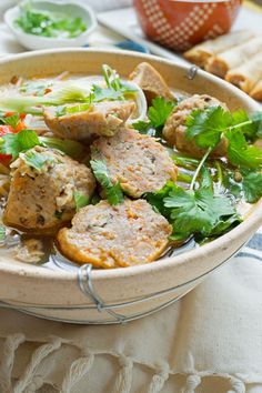 a bowl filled with meat and vegetables on top of a table