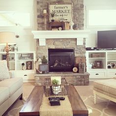 a living room filled with furniture and a fire place in front of a stone fireplace