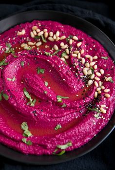 a bowl filled with beet hummus and garnish