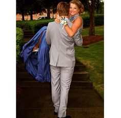 a man in a suit carrying a woman on his back while walking down some steps