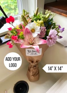 a bouquet of flowers sitting on top of a sink next to a sign that says add your logo