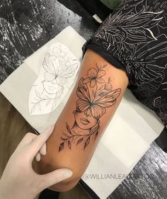 a woman's arm with flowers and leaves tattoo on the left side of her body