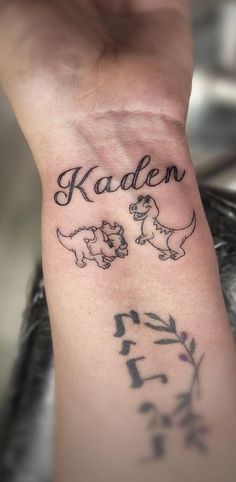 a person with a tattoo on their wrist that says kadlen and two small dogs