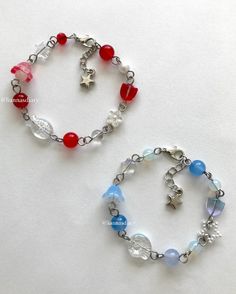 two bracelets with beads and charms on white table top next to eachother