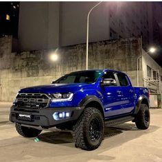 a blue pick up truck parked in front of a building