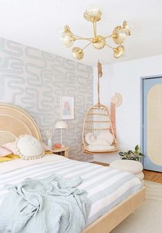 a bed room with a neatly made bed and a birdcage hanging from the ceiling