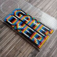 a piece of art made out of legos sitting on top of a wooden floor