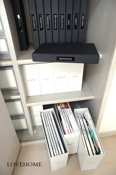 some records are stacked on top of each other in a book shelf with white drawers