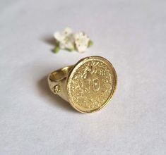 Beautiful solid gold old coin signet ring, vintage-style big round boho jewelry for women, available in 9k or 14k yellow gold.  This handmade gold ring is made by minting a beautiful Swiss coin decorated with flowers and attaching it to a solid gold band. The band features three small dots on each side, adding a unique, vintage character to this jewelry piece. It is available in 9k or 14k solid yellow gold.  This statement ring is exquisite and delicate, with a charmingly romantic and vintage to Vintage Engraved Coin Signet Ring, Vintage Coin Signet Ring As Gift, Vintage Coin Shaped Signet Ring Gift, Vintage Coin Signet Ring For Gift, Antique Coin-shape Engraved Signet Ring, Antique Coin Shaped Engraved Signet Ring, Antique Engraved Coin Signet Ring, Gold Coin-shaped Engraved Signet Ring, Gold Engraved Coin Signet Ring