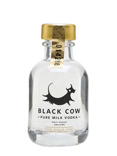 a bottle of black cow pure milk with gold trimmings on the top and bottom