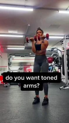 a woman is lifting two dumbbells in a gym with the words do you want toned arms?