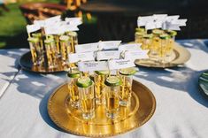 there are many glasses with limes in them on the plate and place card holders