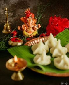 there is an elephant figurine sitting on a plate next to some flowers and candles