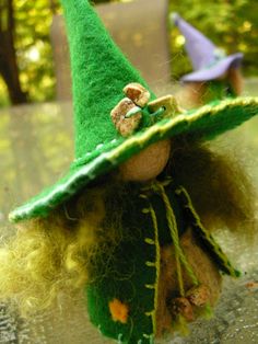 a small doll wearing a green witches hat