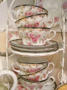 a stack of tea cups and saucers sitting on top of a counter