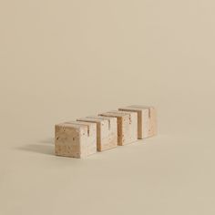 three blocks of cement sitting on top of each other in front of a beige wall