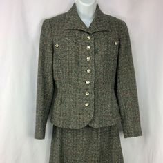 "A lovely lined women's suit by Fairbrooke--vintage 1940s or 1950s. Black and gray/white wool tweed with several secondary colors worked in, including teal, green, red, and orange. Interesting detailing on the chest, with smaller metal buttons that match the 7 buttons down the front. Spread-type collar; end of the jacket in front is curved, and the sleeves each have a small vent; 2 small pockets on either side. Jacket lining is sewn in all around; skirt lining is dark gray with pinked hem. There is no size tag, but I'm guessing this suit to be a small--make sure to see the measurements below! There is some staining and careful seam repair on the underarms--see last photo, Jacket measurements-- Underarm seam to underarm seam across back: about 18\" Waist: about 15.5\" Sleeve, from middle of Formal Fitted Wool Tweed Dress, Formal Tweed Fitted Skirt Suit, Classic Fitted Wool Skirt Suit, Spring Fitted Wool Tweed Dress, Spring Wool Tweed Fitted Dress, Classic Tweed Skirt Suit For Office, Classic Fitted Tweed Dress For Fall, Spring Wool Tweed Dress Fitted, Spring Wool Tweed Dress