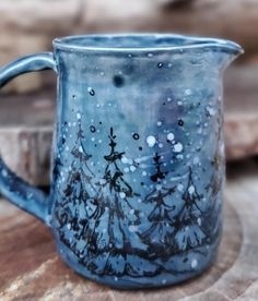 a blue mug sitting on top of a wooden table next to a piece of wood