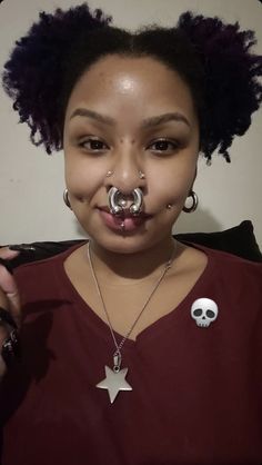 a young woman with piercings on her nose and nose ring in the shape of a skull