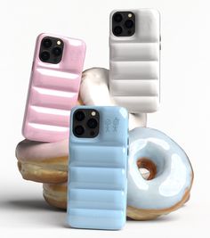 three cell phones sitting next to each other on top of donuts and doughnuts