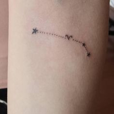 a small star tattoo on the side of a woman's thigh, which is attached to a string