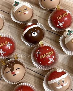 chocolates decorated like santa claus and reindeer heads on a wooden table with christmas decorations