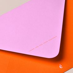 an orange and pink computer mouse pad on top of another one with the word love written on it