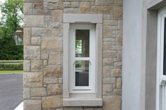 a white window sitting on the side of a stone building