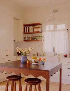 a kitchen table with two stools next to it