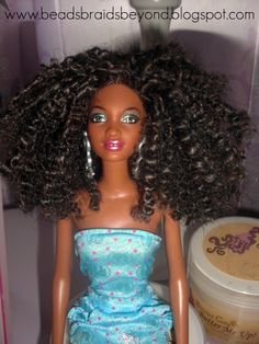 the doll is wearing a blue dress and has curly hair