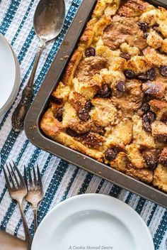 a casserole dish with bread and raisins in it on a table