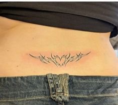 a woman's stomach with an arrow tattoo on it