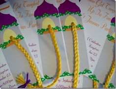 some paper fan shaped like trees with yellow braids on them and purple ribbon around the edges