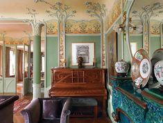 a living room filled with furniture and paintings on the walls