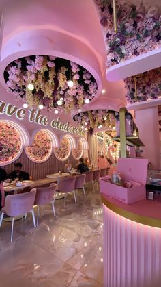 the inside of a restaurant decorated with pink flowers