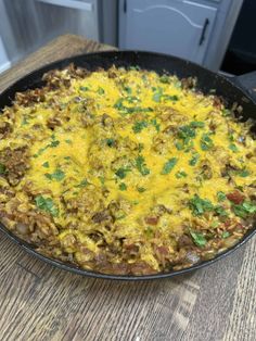 a skillet filled with food sitting on top of a wooden table