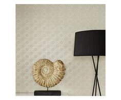 a lamp on a table next to a wallpapered wall and a decorative shell