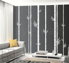 a living room with black and white wallpaper, bamboo trees on the wall and a couch