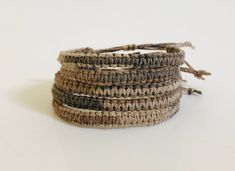 three brown and white crocheted bracelets on a white surface