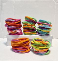 there are many different colors of hair ties on the white box and one is multicolored