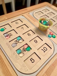 a close up of a wooden table with numbers on it and a bowl of beads