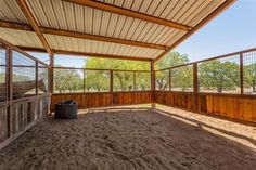 the inside of an enclosed area with a trash can and fenced in area next to it